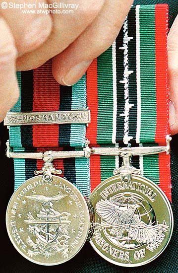 Jack Vennes pins
 his Normandy and Prisoner of War medals on his legion jacket